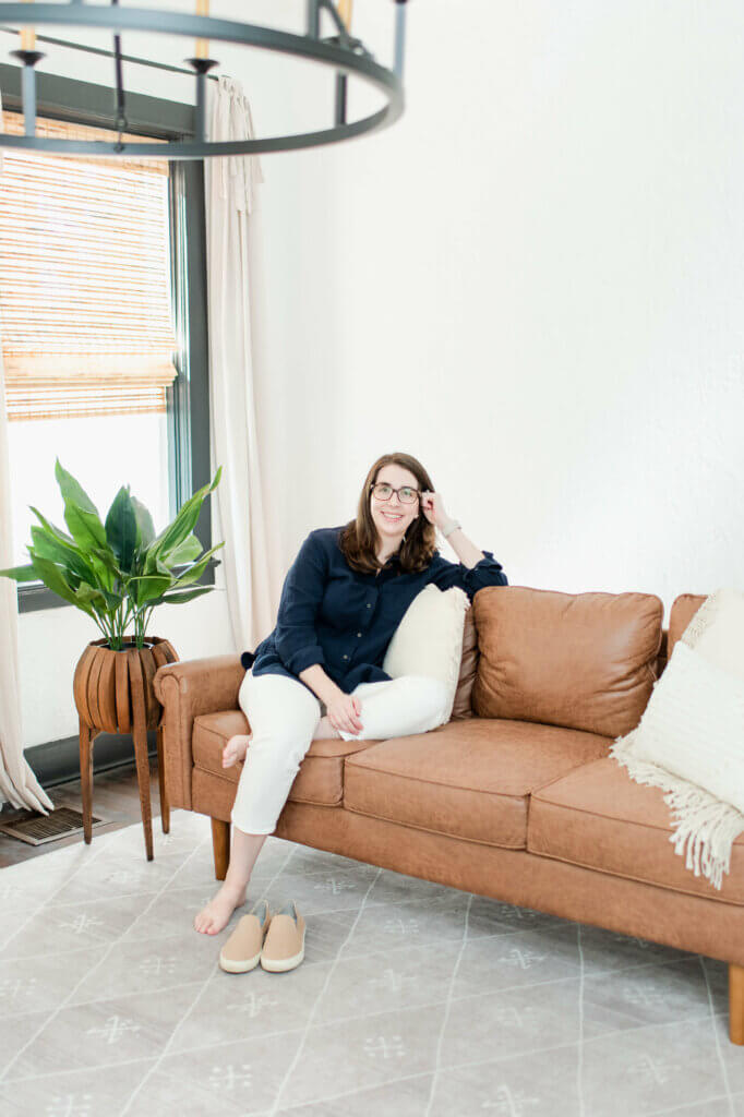 Lauren Scheffer Travel Agent for Families with Food Allergies sitting on leather sofa in Travel Accommodations With Food Allergies.