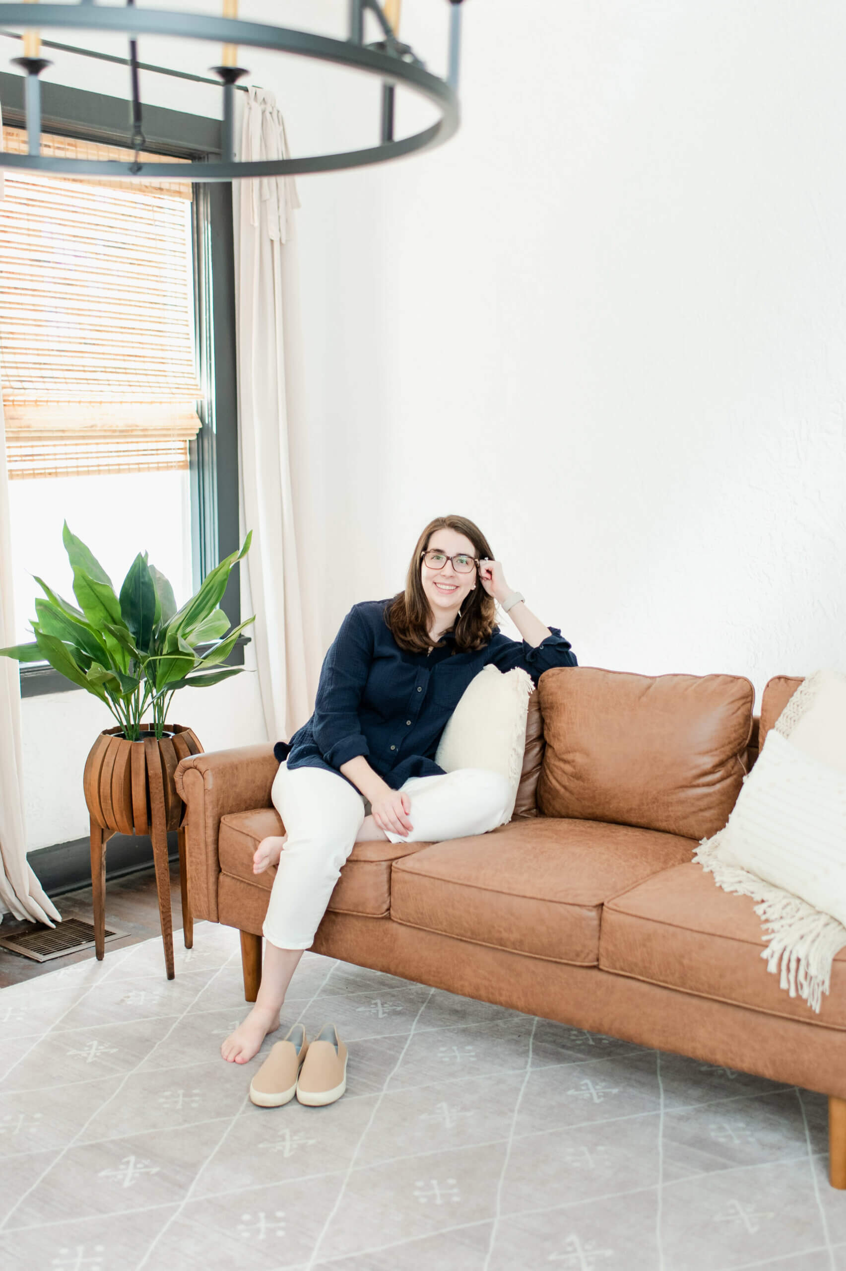 Lauren Scheffer Travel Agent for Families with Food Allergies sitting on leather sofa in Travel Accommodations With Food Allergies.