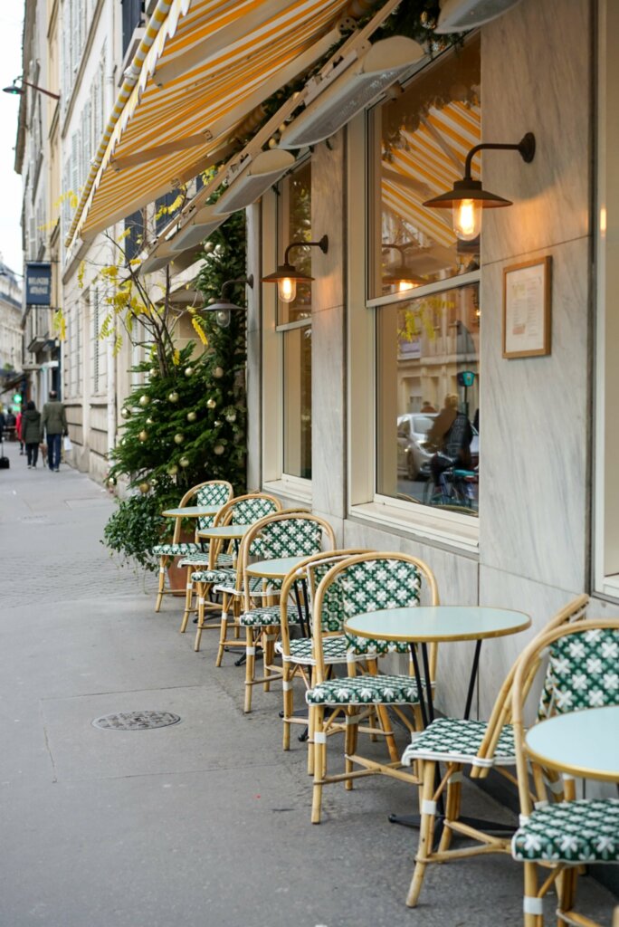 exploring france with food allergies, a cafe in france with green and cream chairs on the sidewalk