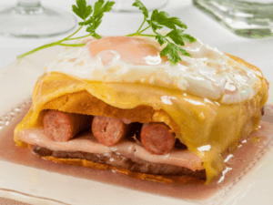 - This sandwich is made with bread, ham, sausage, and steak,  covered with melted cheese and an egg on top!