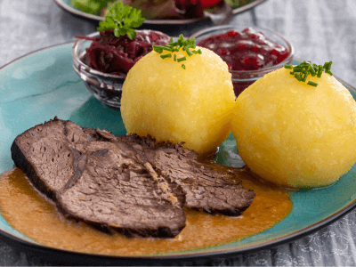 This pot roast or "sour roast" is due to the pickling of the meat like veal, beef, or pork. It is then served in a sweet and sour sauce.