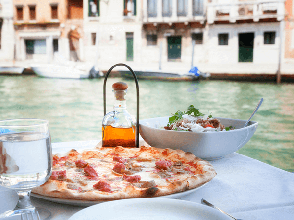 shellfish free pizza in italy overlooking water.
