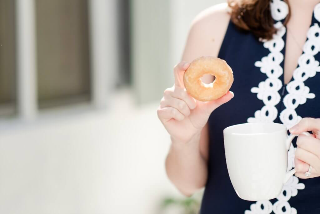Lauren Scheffer, a food allergy travel agent holding a gluten free donut