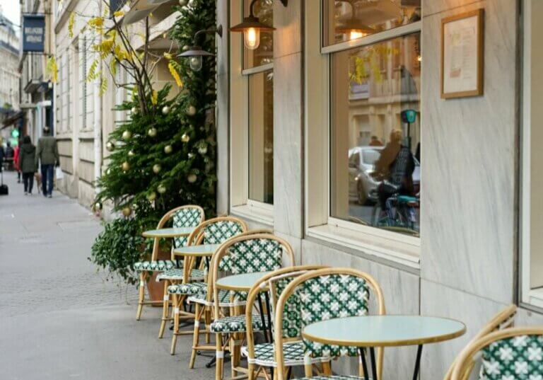 exploring france with food allergies, a cafe in france with green and cream chairs on the sidewalk